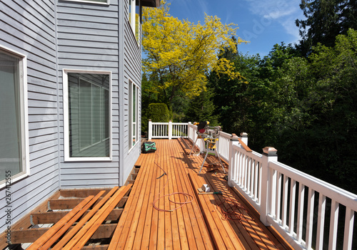 Fotomural Outdoor red wooden cedar deck being remodeled with new floor boards freshly inst
