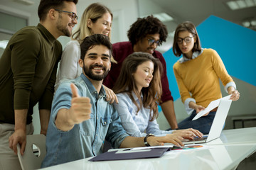 Group of young multiethnic business people working and communicating together in creative office