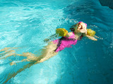 Fototapeta  - dziewczynka pływająca w basenie