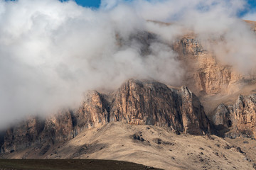 Poster - peaks of rocks and mountain peaks in thick white clouds against a blue sky.  Lake Bylym in the Kabardino-Balkarian Republic of Russia