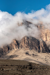 Poster - peaks of rocks and mountain peaks in thick white clouds against a blue sky.  Lake Bylym in the Kabardino-Balkarian Republic of Russia