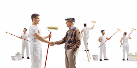 Wall Mural - Decorator with a roller painter shaking hands with a senior and people painting wall