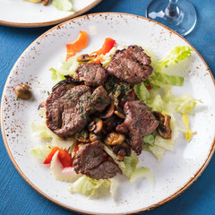 Wall Mural - Meat salad with fresh vegetables on a plate. Top view. Closeup