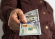 © Vergani Fotografia - Banknotes of USA currency: Dollar. Old retired person paying in cash.