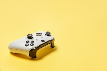 White joystick gamepad, game console on yellow colourful trendy modern fashion pin-up background. Computer gaming competition videogame control confrontation concept. Cyberspace symbol