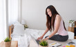 © weedezign - Asian female freelancer sit on table working at laptop in bedroom at home.Work at home concept.work from home concept.casual tank top clothing.