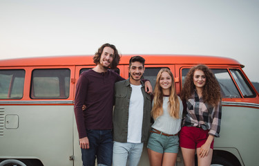 Wall Mural - A group of young friends standing on a roadtrip through countryside.