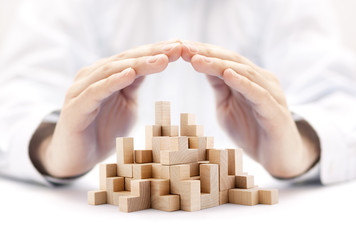 Poster - Safety business development concept. Wooden blocks covered by hands. 