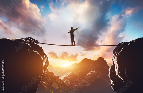 Fotomural Man walking on rope between two high mountains