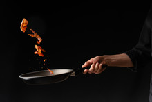 Cooking Bacon On A Griddle, On A Black Background