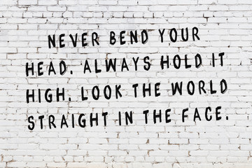 white brick wall with painted black motivational quote inscription