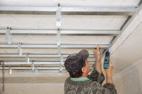 Man Is Working With A Drill And Making Stretch Ceiling