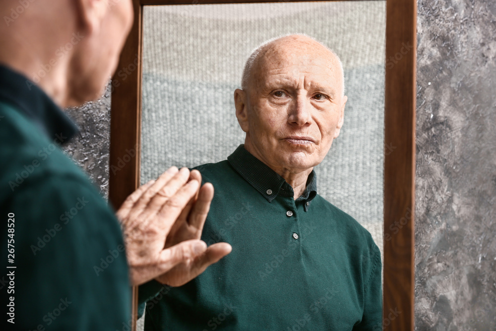 Senior man looking in mirror