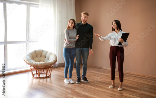 Fotografía Real estate agent showing young couple a new house