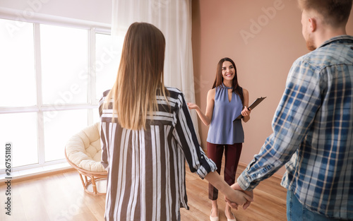 Fotografía Real estate agent showing young couple a new house