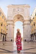 Young blonde tourist woman walking on the Rua Augusta street in Lisbon city and exploring old architecture, Portugal