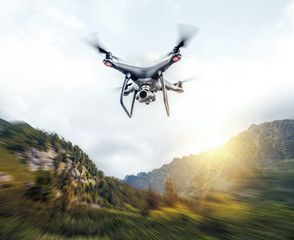 Wall Mural - Dark drone in the air against the backdrop of a mountain landscape.