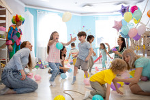 Happy Children And Their Parents Entertain And Have Fun With Color Balloon On Kids Birthday Party