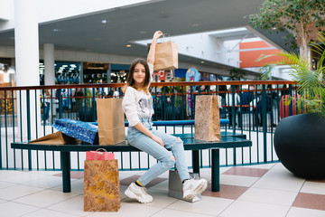 Wall Mural - shopping, happiness and people concept - smiling stylish teenage girl with shopping bags. shopping concept