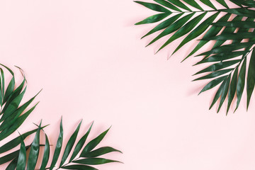 Wall Mural - Summer composition. Tropical palm leaves on pastel pink background. Summer concept. Flat lay, top view, copy space
