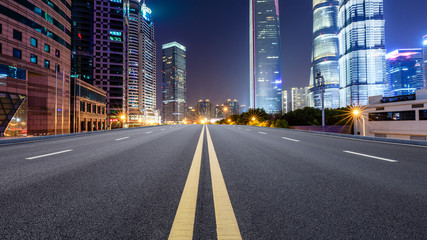 Shanghai modern commercial office buildings and empty asphalt highway at night