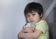 © Anchalee - Dramatic portrait of little boy sitting on stair and cuddling teddy bear with scared face,Unhappy Child sitting alone and looking out with worrying face,Toddler boy on corner punishment sitting.