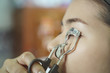 Beauty concept.Close up of woman using eyelash curler while looking in makeup mirror at home .selective focus
