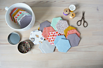 Wall Mural - Hexagon english paper piecing templates, white cup, thread, retro scissors and metal pins on the wooden table