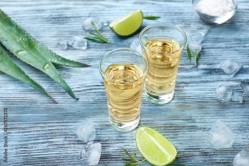 Shots of tequila on wooden table