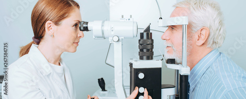 Cuadros en Lienzo Senior patient checking vision with special eye equipment