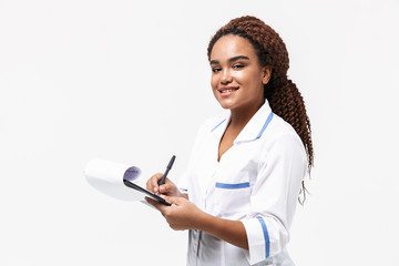 Image of smiling african american nurse or doctor woman writing medical case report