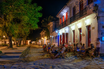 Fototapete - Night view of street of historical center with tables of restaurant in Paraty, Rio de Janeiro, Brazil. Paraty is a preserved Portuguese colonial and Brazilian Imperial municipality