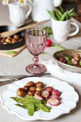 Poster - young summer vegetables-fried radish, young peas and young potatoes. dinner served at the table, beautiful table setting.