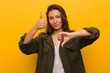 Young european woman isolated over yellow background showing thumbs up and thumbs down, difficult choose concept