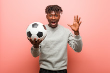 Young Fitness Black Man Holding A Soccer Ball Celebrating A Victory Or Success