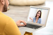 © New Africa - Young man using video chat on laptop at home, closeup. Space for design