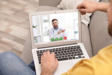 Canvas Print - Young man using video chat on laptop in living room, closeup. Space for design