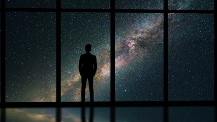 Wall Mural - The man standing near the window on the starry sky background. time lapse