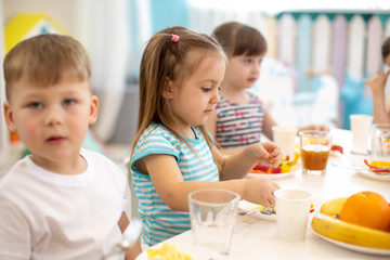 Wall Mural - Group of children eating healthy food in day care centre