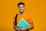 Fototapeta  - Young student man holding books smiling and raising thumb up