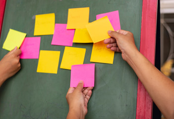 Close up businessman hands holding note sticky for brainstorm ans share idea strategy workshop business.Brainstorming concept