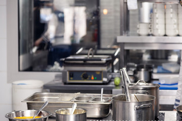 Professional cuisine restaurant. Kitchen utensils, plate with metal pots with lids and scoops. Сoncept violation conditions and shelf life products, food poisoning, sanitary inspection