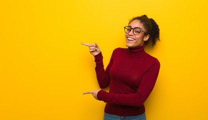 Wall Mural - Young black african american girl with blue eyes pointing to the side with finger