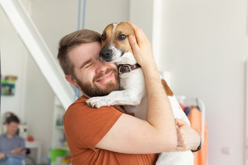 Animal, pet and people concept - Smiling man in casual mustard t-shirt with his jack russell terrier