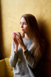 © Kiryl Lis - Young pretty girl with long hair drinking coffee or tea  in the cafe.