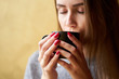 © Kiryl Lis - Beautiful girl with red nails holding a cup of coffee. Closeup view of hands with coffee.