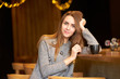 © Kiryl Lis - Portrait charming attractive woman with long hair and friendly smile siting in the cafe and drinking coffee.