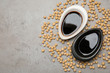 © New Africa - Dishes of soy sauce and beans on grey background, flat lay. Space for text