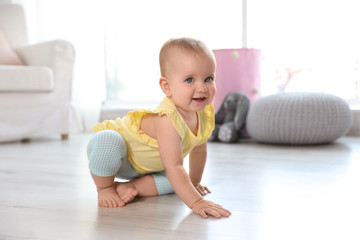 Cute baby girl on floor in room