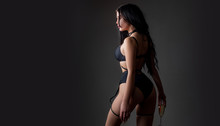 Female In Sexy Bikini. Lingerie Sexy Girl Model In Darkness. Sexy Lingerie. Bondage And Bdsm Concept. Confident Lover. Seductive Temptress. Slim Woman Dressed In Black Lingerie And Tied With Ropes